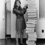 Margaret Hamilton stands next to the computer program she and her team wrote to land a lunar module on the moon.
